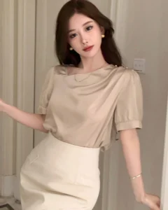 Blusa de satén con cuello asimétrico y manga abullonada plisada