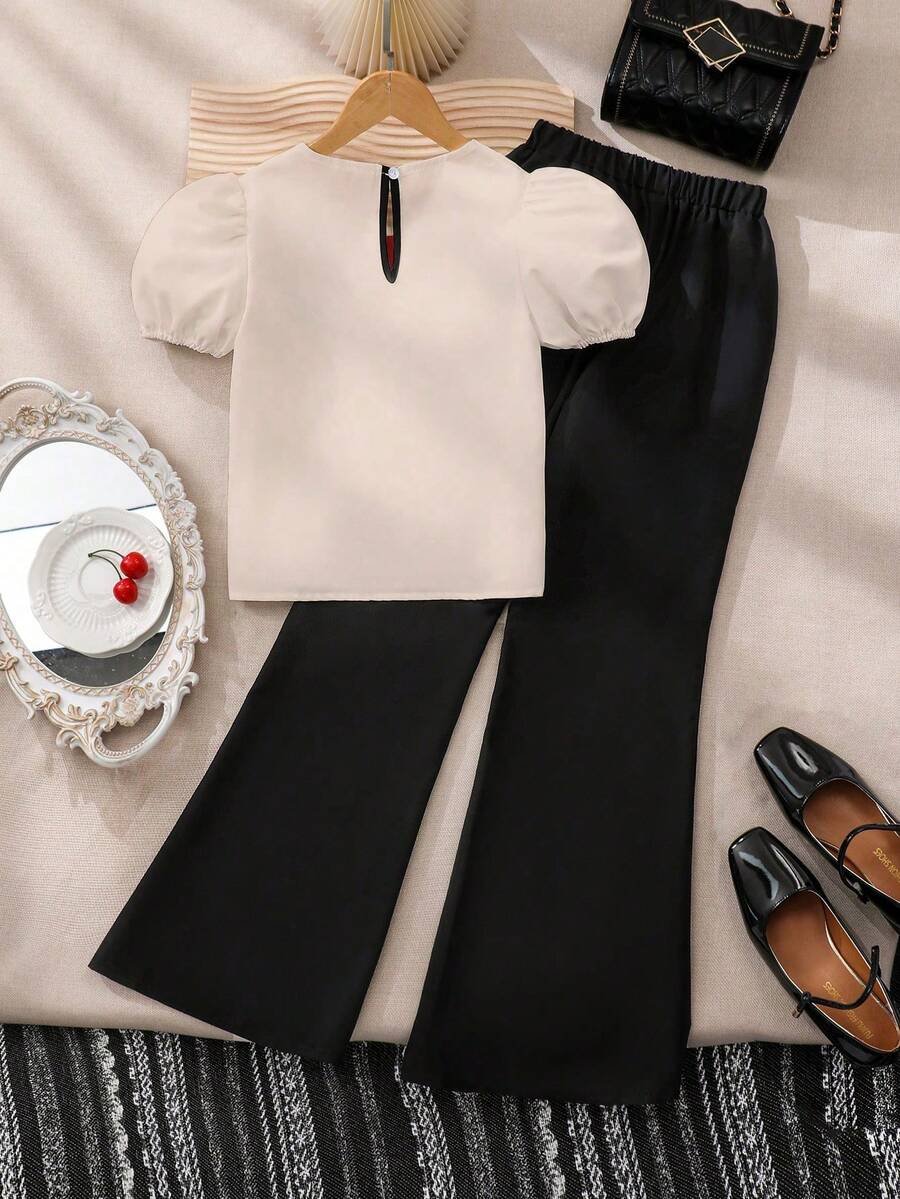 Blusa blanca con cuello elegante, combinada con pantalones acampanados - Imagen 3