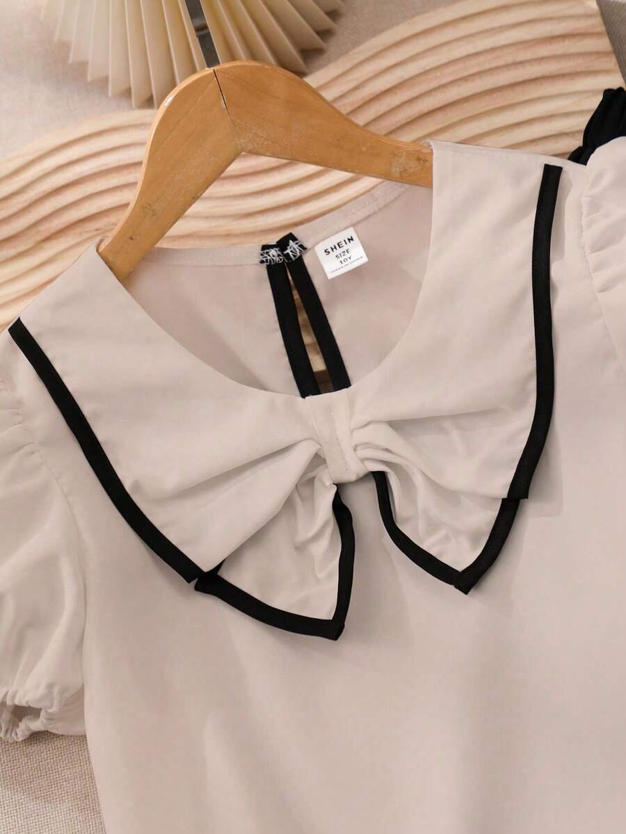 Blusa blanca con cuello elegante, combinada con pantalones acampanados - Imagen 2